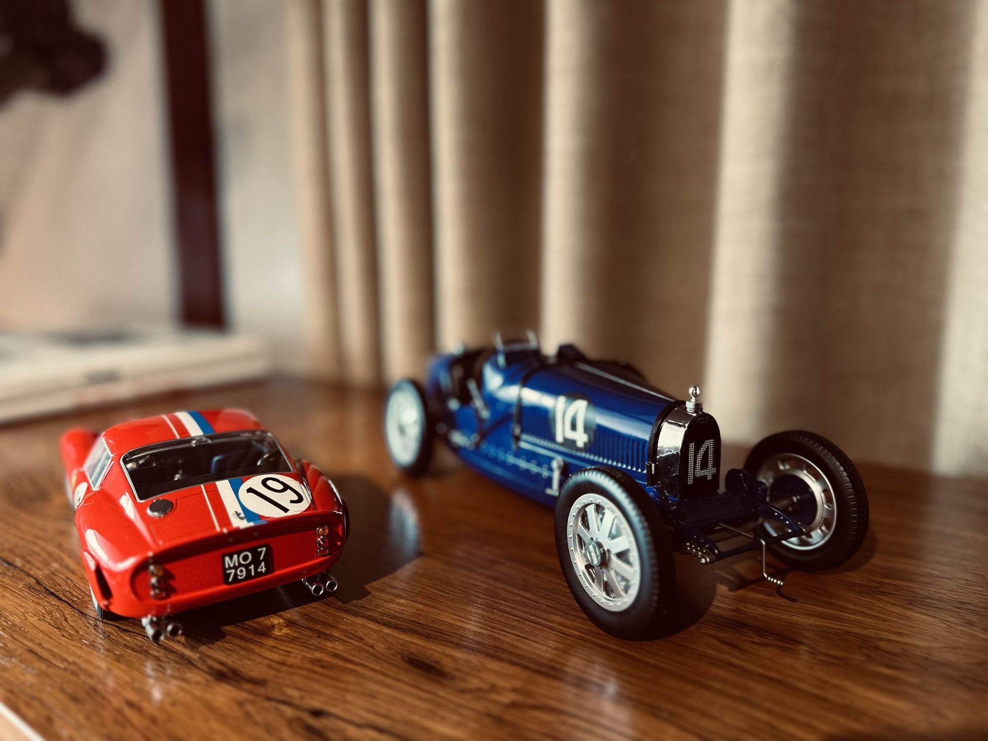 Bugatti Type 35 and Ferrari 250 GTO model cars side by side.